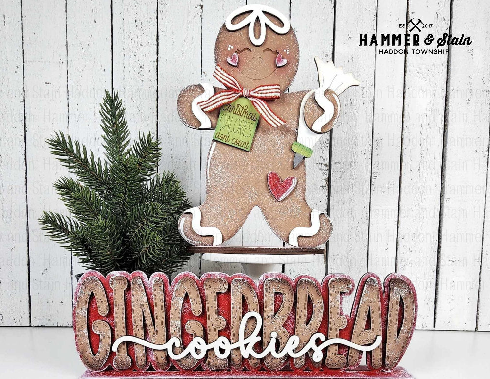 Decorative gingerbread man with 'Gingerbread cookies' sign on a wooden background
