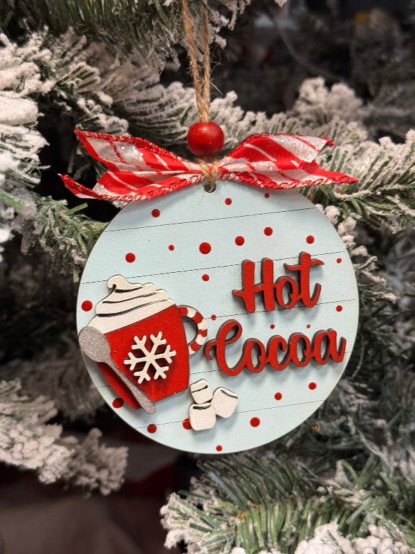 Christmas ornament with 'Hot Cocoa' text and candy cane design on a tree.