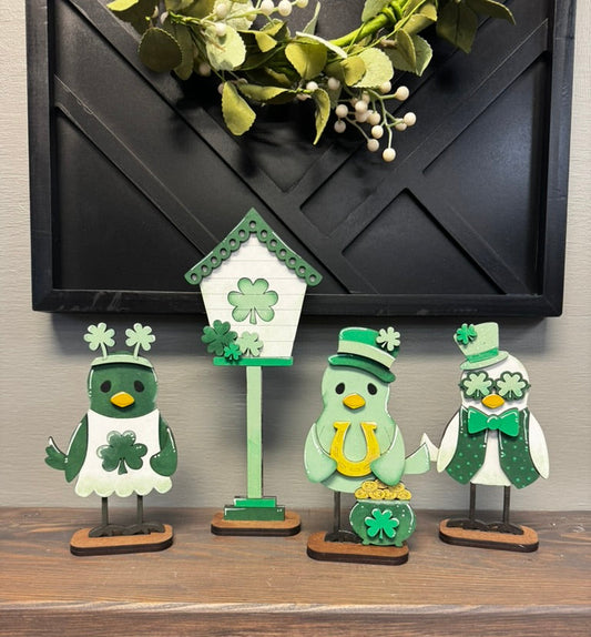 Set of decorative figures with shamrock designs on a wooden surface.